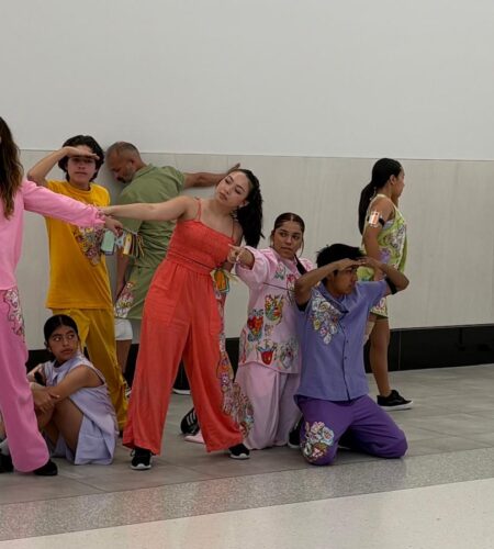 Jóvenes bailarines interactúan en el Aeropuerto de San Diego para abordar la migración